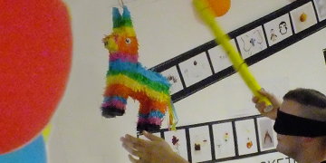 Schüler erwischt mit verbundenen Augen die gefüllte Pinata