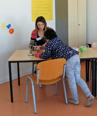 Schülerin spielt mit Kind